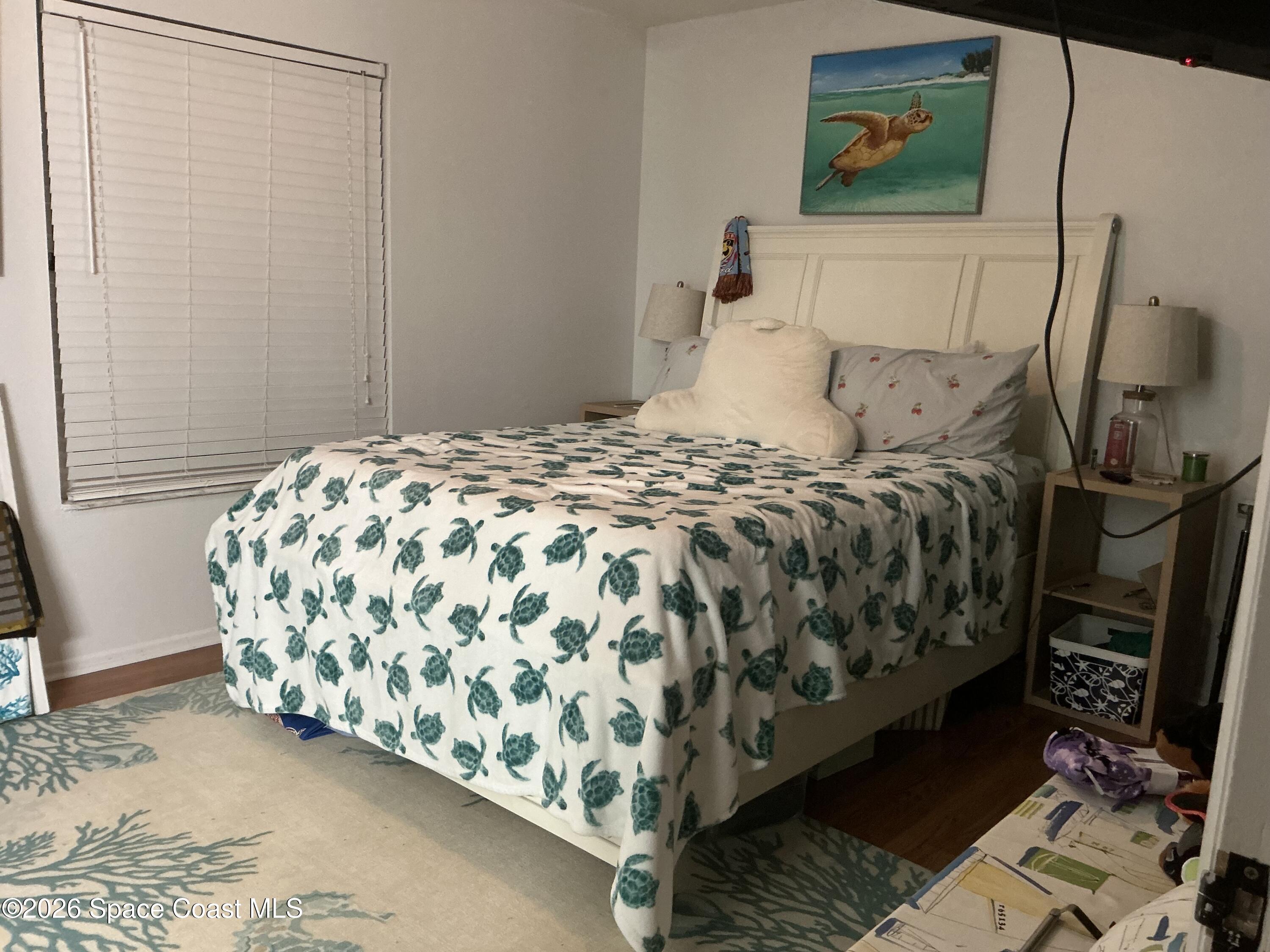 1470 Sheafe Avenue Northeast, Unit 106 Palm Bay, FL 32905 - Photo 8 of 16 a bedroom with a bed and a painting on the wall