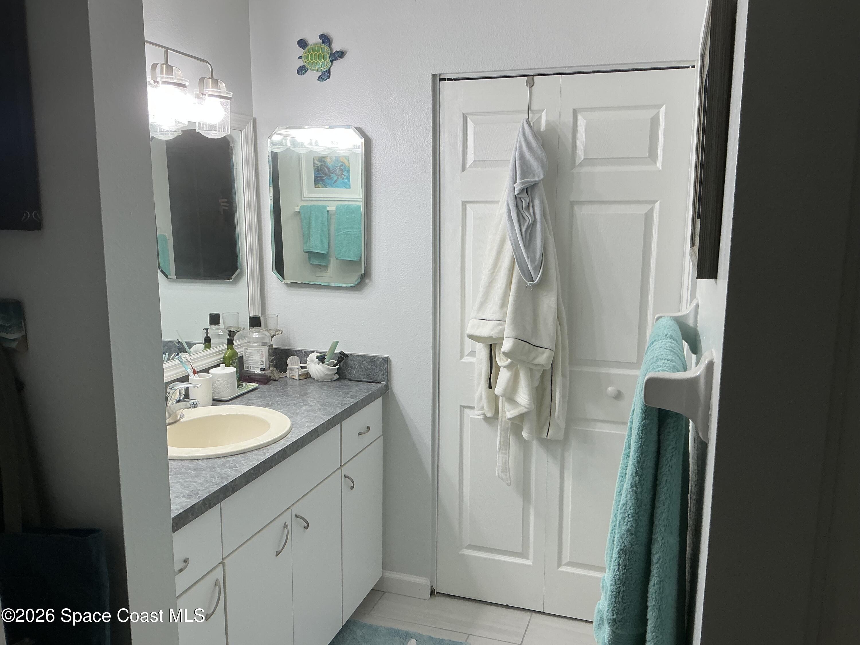1470 Sheafe Avenue Northeast, Unit 106 Palm Bay, FL 32905 - Photo 9 of 16 a bathroom with a double vanity sink mirror and shower