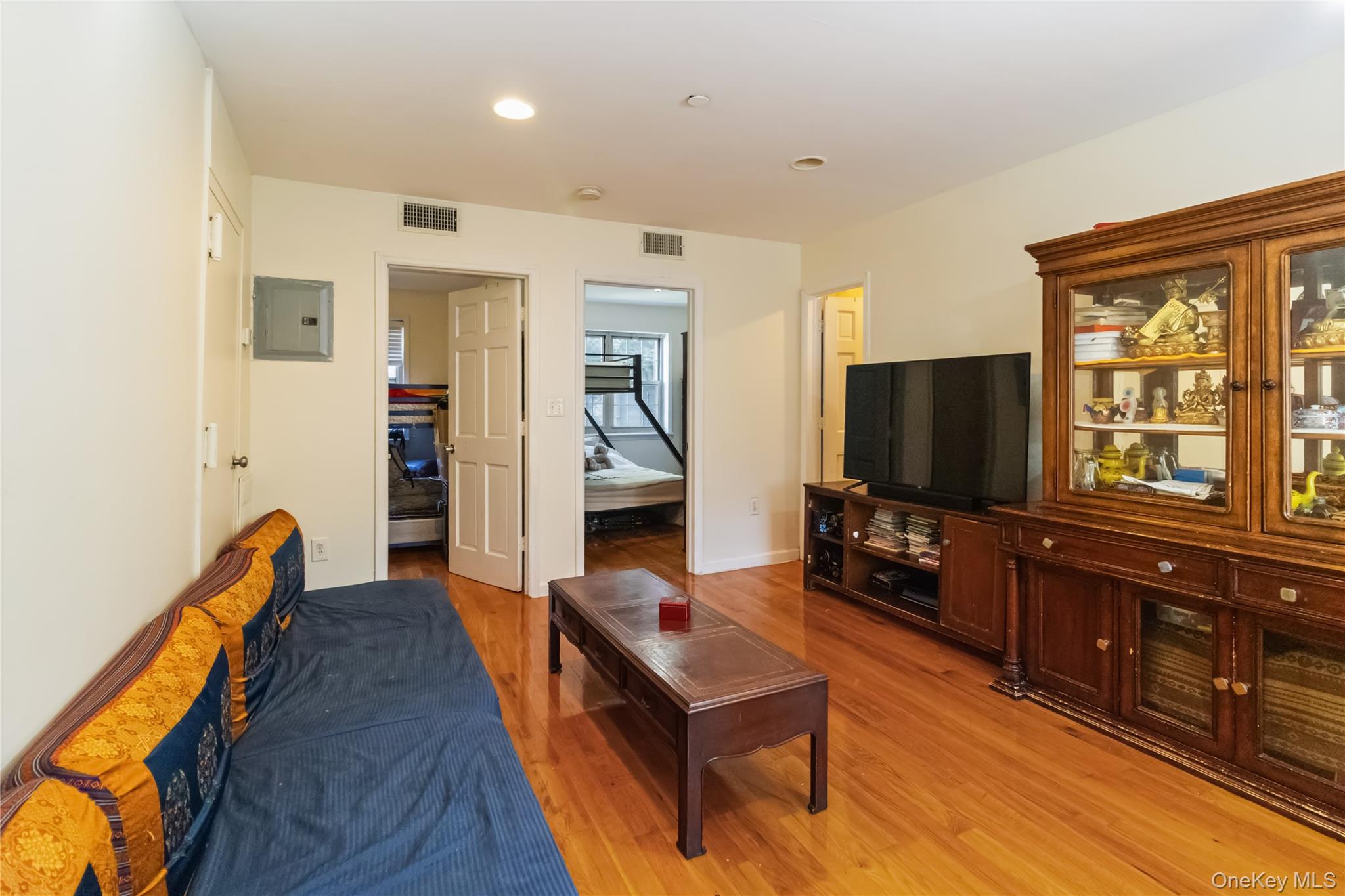 10223 43rd Avenue, Unit 2B Queens, NY 11368 - Photo 3 of 15 a living room with furniture a flat screen tv and a refrigerator