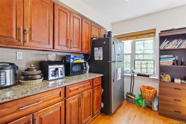 a kitchen with granite countertop a refrigerator a stove a sink and dishwasher