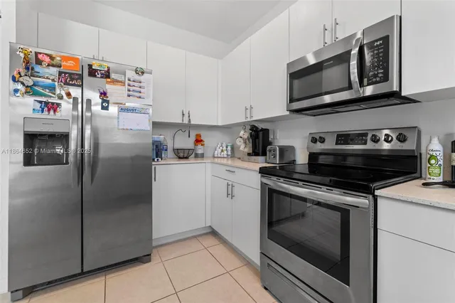 a kitchen with stainless steel appliances granite countertop a refrigerator a stove a microwave oven with cabinets