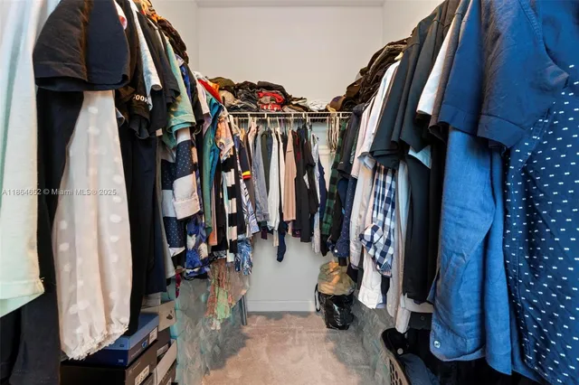 a view of walk in closet with clothes