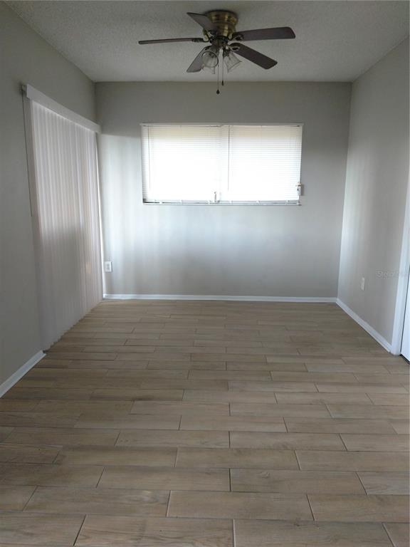 4400 Castlepalm Road Orlando, FL 32839 - Photo 11 of 38 an empty room with wooden floor fan and windows