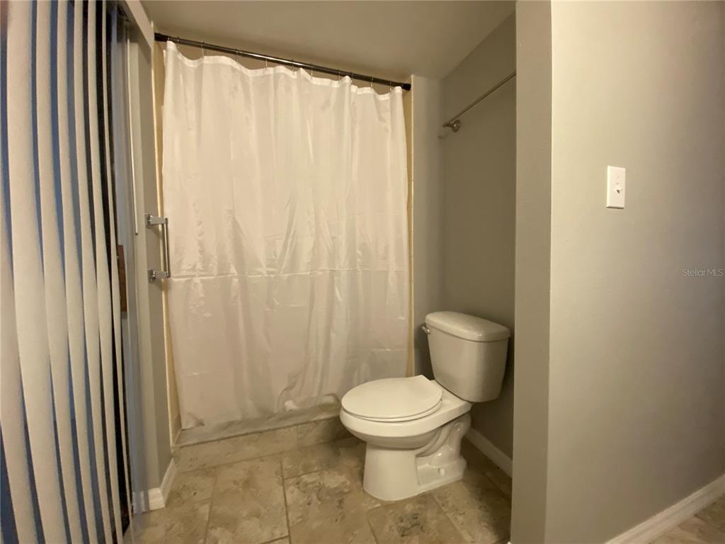 4400 Castlepalm Road Orlando, FL 32839 - Photo 13 of 38 a white toilet sitting next to a shower curtain