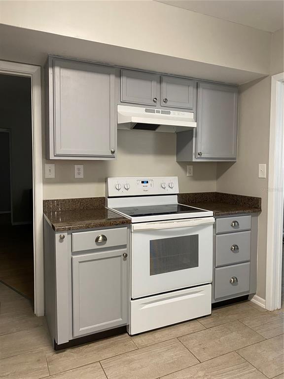 4400 Castlepalm Road Orlando, FL 32839 - Photo 8 of 38 a kitchen with granite countertop white cabinets and white stove