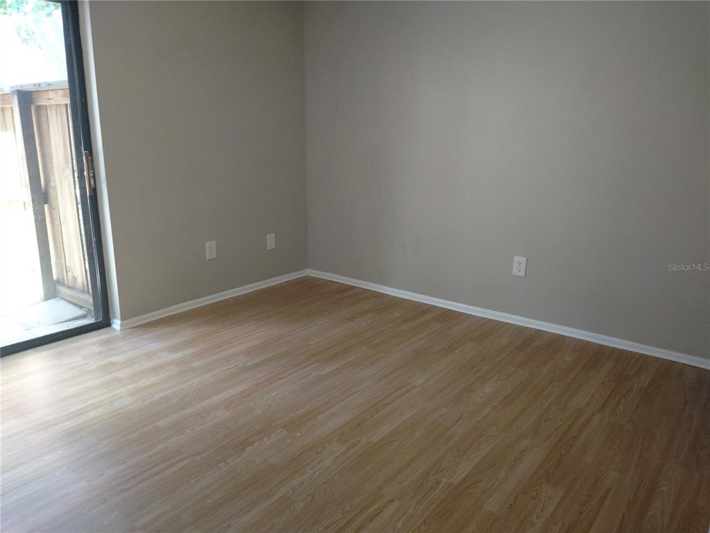 4400 Castlepalm Road Orlando, FL 32839 - Photo 10 of 38 an empty room with wooden floor and windows
