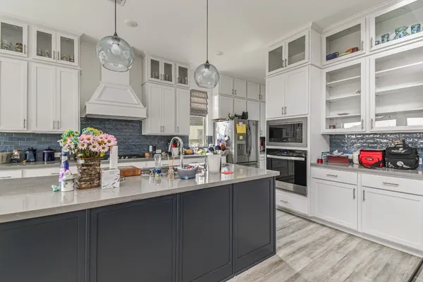 a kitchen with kitchen island granite countertop a sink stainless steel appliances and cabinets