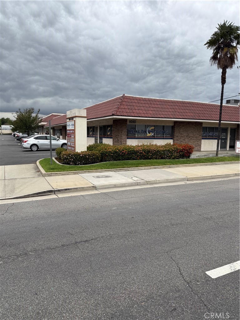 a front view of a house with a garden and yard