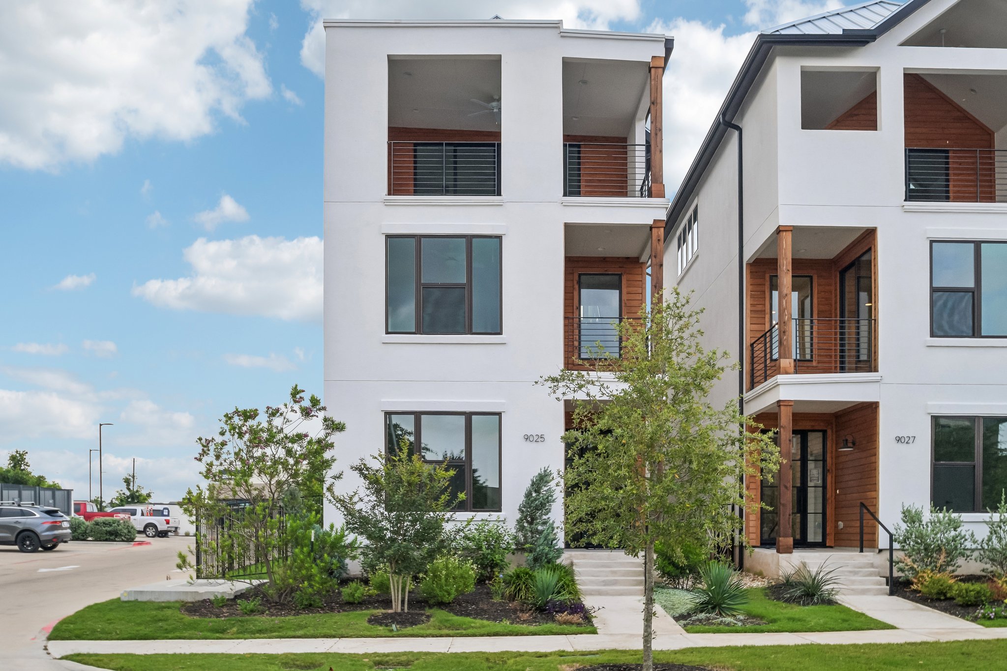 9025 Cattle Baron Path Austin, TX 78747 - Photo 2 of 32 Modern townhome boasts crisp white exteriors, rich wood accents, and inviting private balconies.