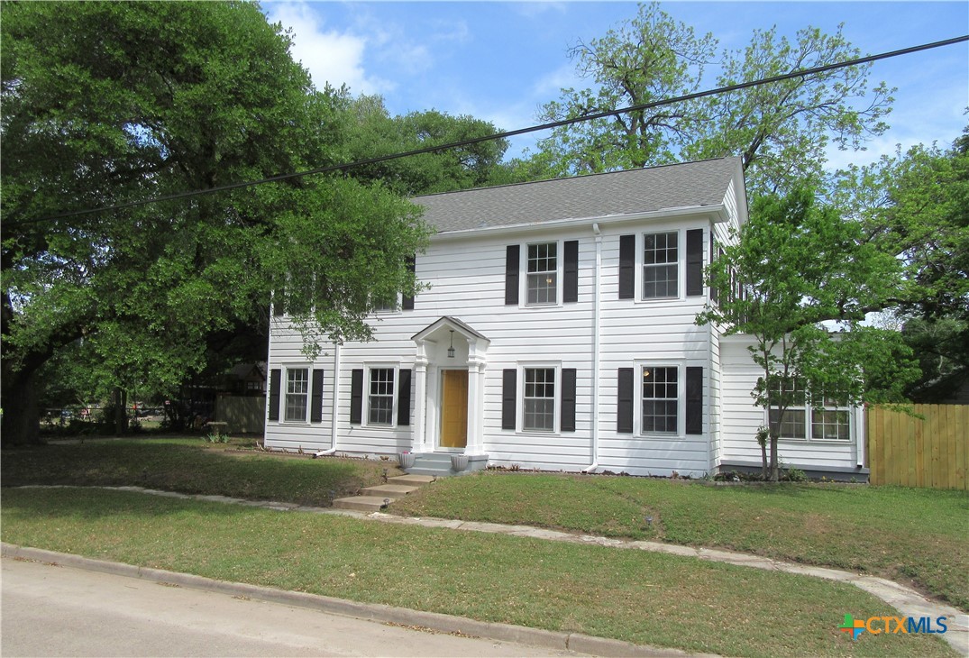 a front view of a house with a garden