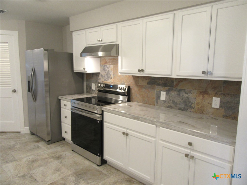 415 Easy Street Marlin, TX 76661 - Photo 12 of 45 a kitchen with stainless steel appliances granite countertop white cabinets and a refrigerator