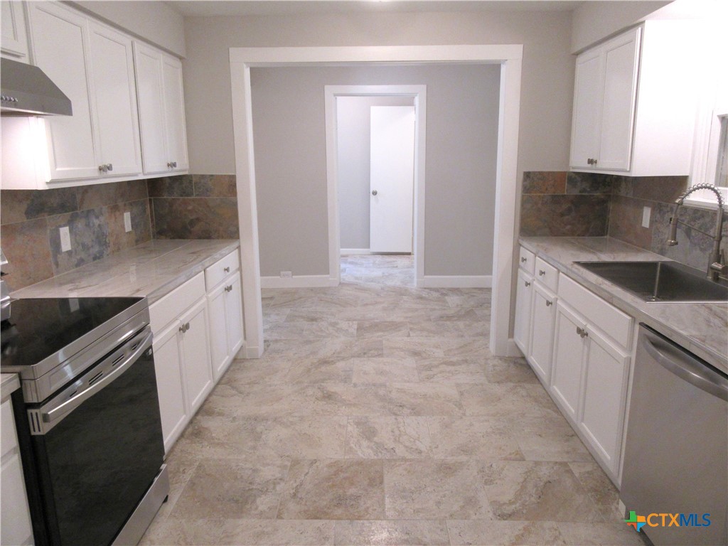 415 Easy Street Marlin, TX 76661 - Photo 13 of 45 a kitchen with granite countertop a sink and cabinets