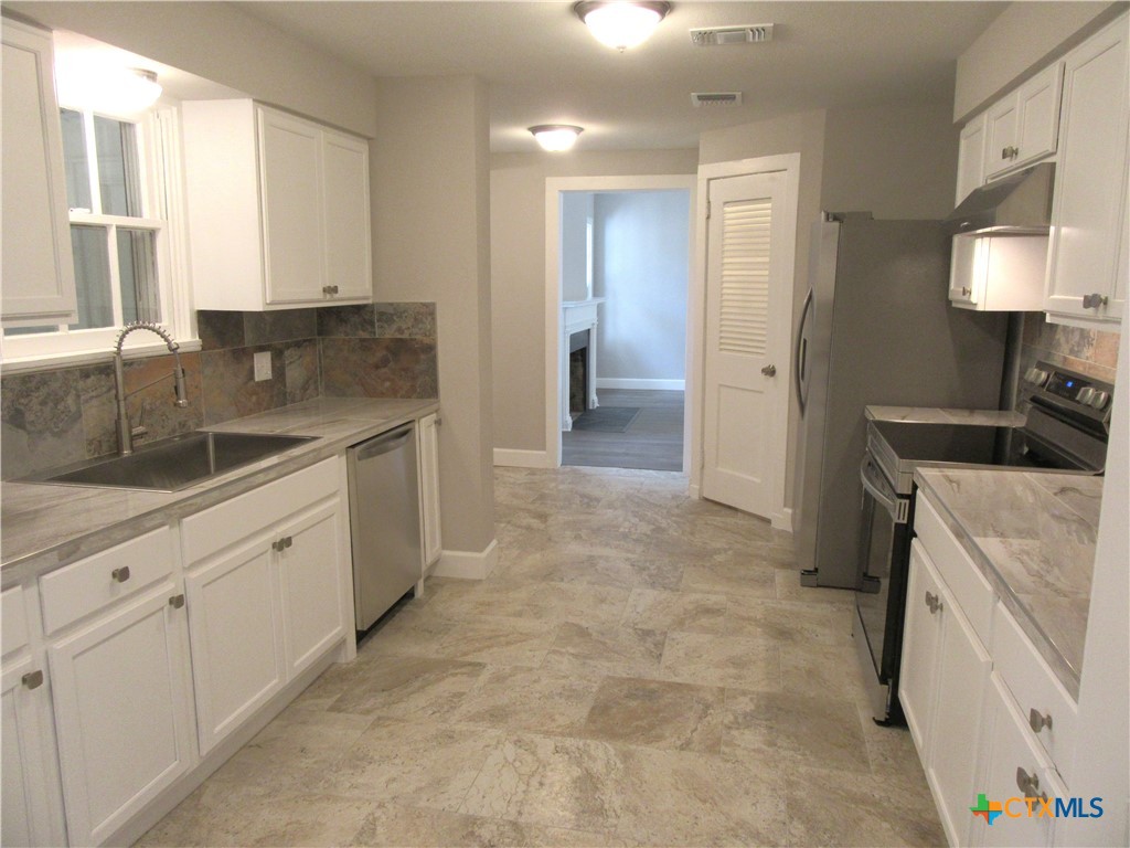 415 Easy Street Marlin, TX 76661 - Photo 14 of 45 a kitchen with a sink and cabinets