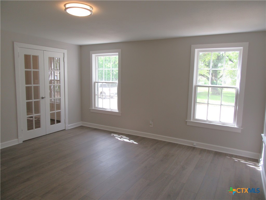 415 Easy Street Marlin, TX 76661 - Photo 21 of 45 an empty room with wooden floor and windows