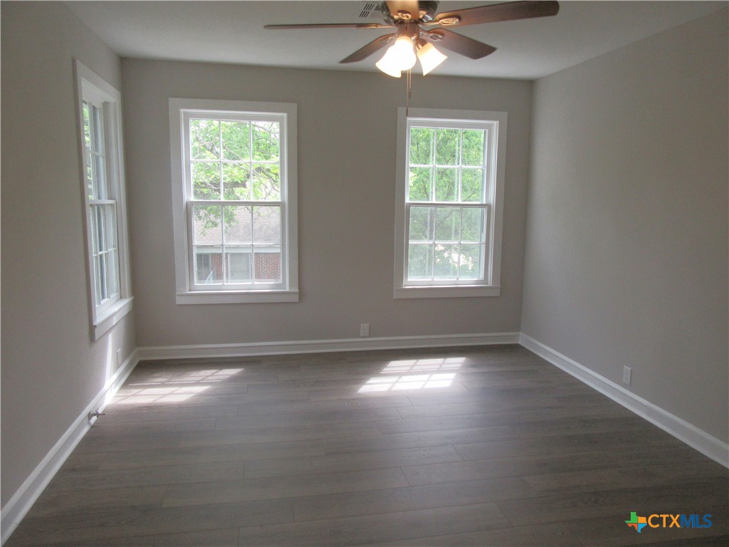 415 Easy Street Marlin, TX 76661 - Photo 26 of 45 an empty room with wooden floor and windows