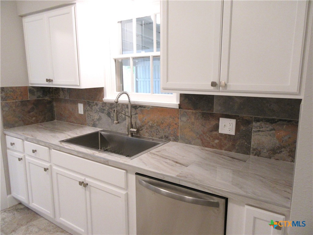 415 Easy Street Marlin, TX 76661 - Photo 10 of 45 a kitchen with granite countertop white cabinets and a sink
