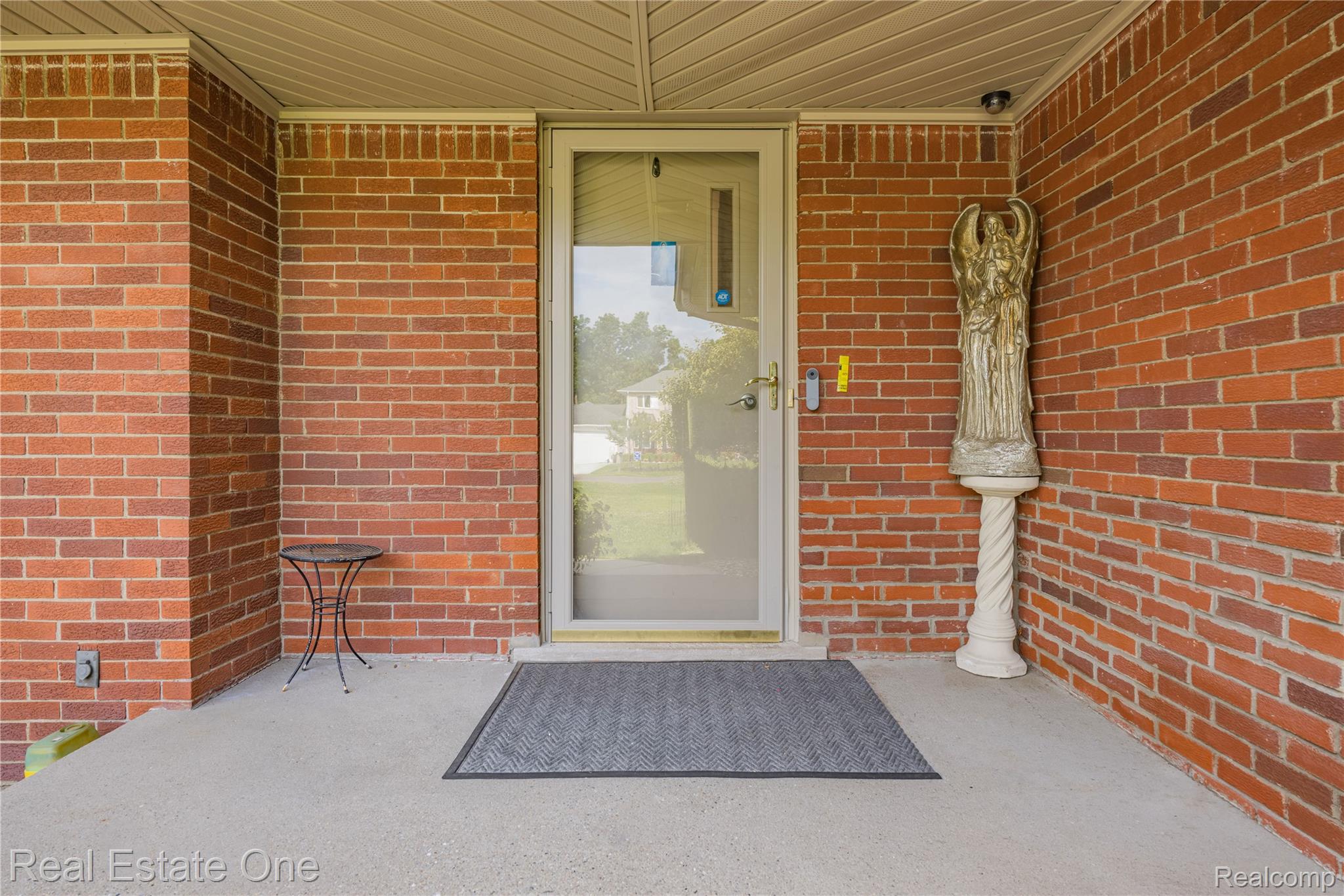 2810 Walbridge Drive Rochester, MI 48307 - Photo 6 of 58 Brick exterior featuring a covered concrete porch and a full-light glass entry door