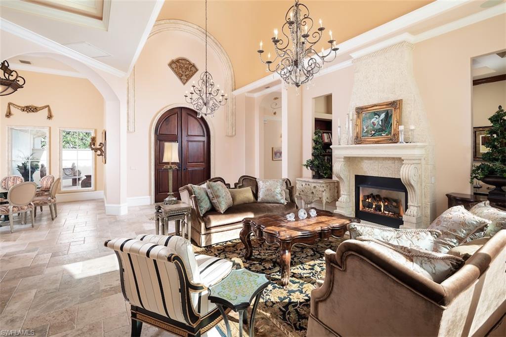 219 Cheshire Way Naples, FL 34110 - Photo 13 of 46 a living room with furniture a fireplace and a chandelier