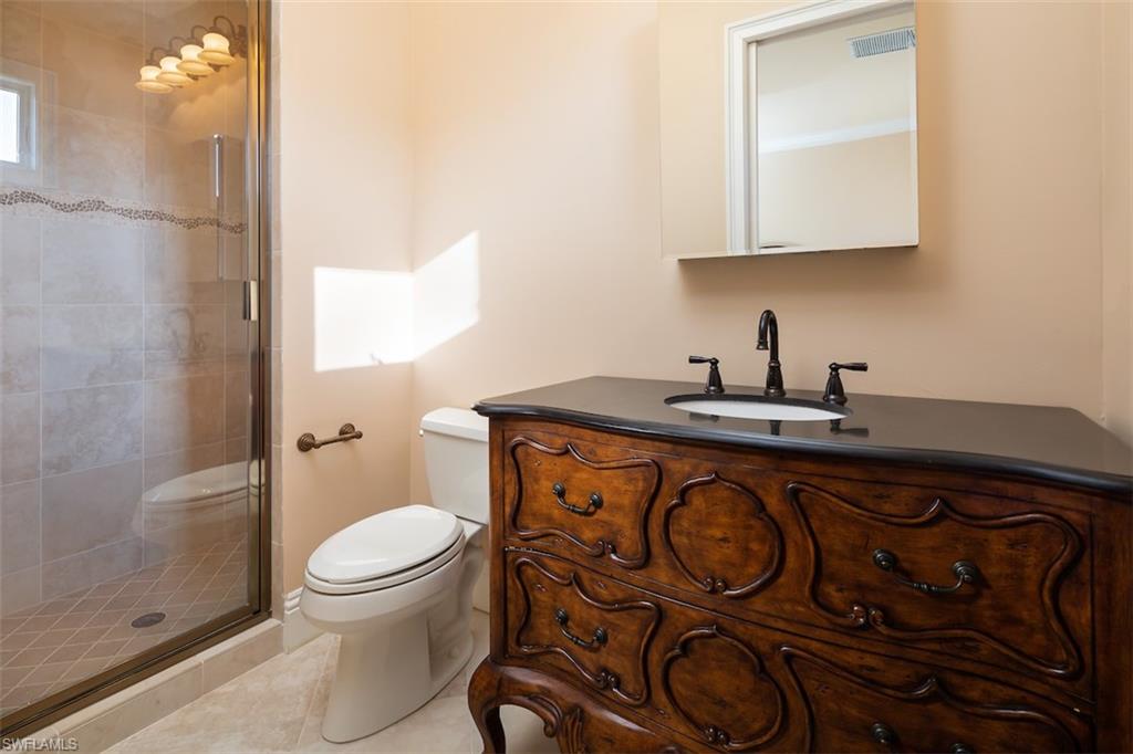 219 Cheshire Way Naples, FL 34110 - Photo 30 of 46 a bathroom with a sink a toilet and a mirror