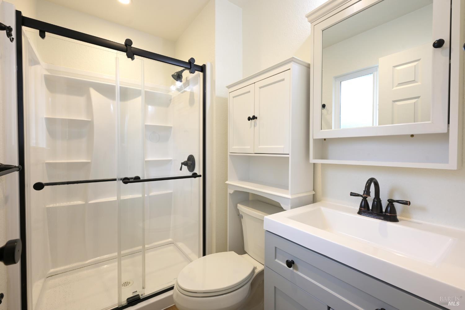 1536 Marlow Road Santa Rosa, CA 95401 - Photo 13 of 21 a bathroom with a sink a mirror a toilet and shower