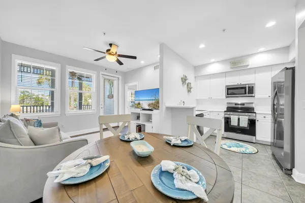 a kitchen with sink refrigerator dining table and chairs
