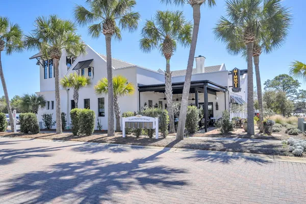 a front view of a building with palm trees