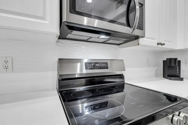 a stove top oven sitting inside of a kitchen