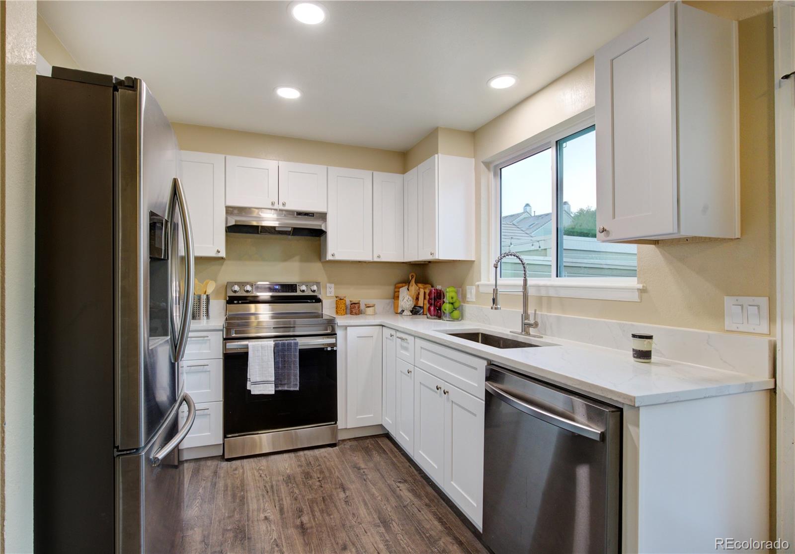 2138 Ranch Drive Westminster, CO 80234 - Photo 11 of 31 a kitchen with stainless steel appliances a sink cabinets and a window