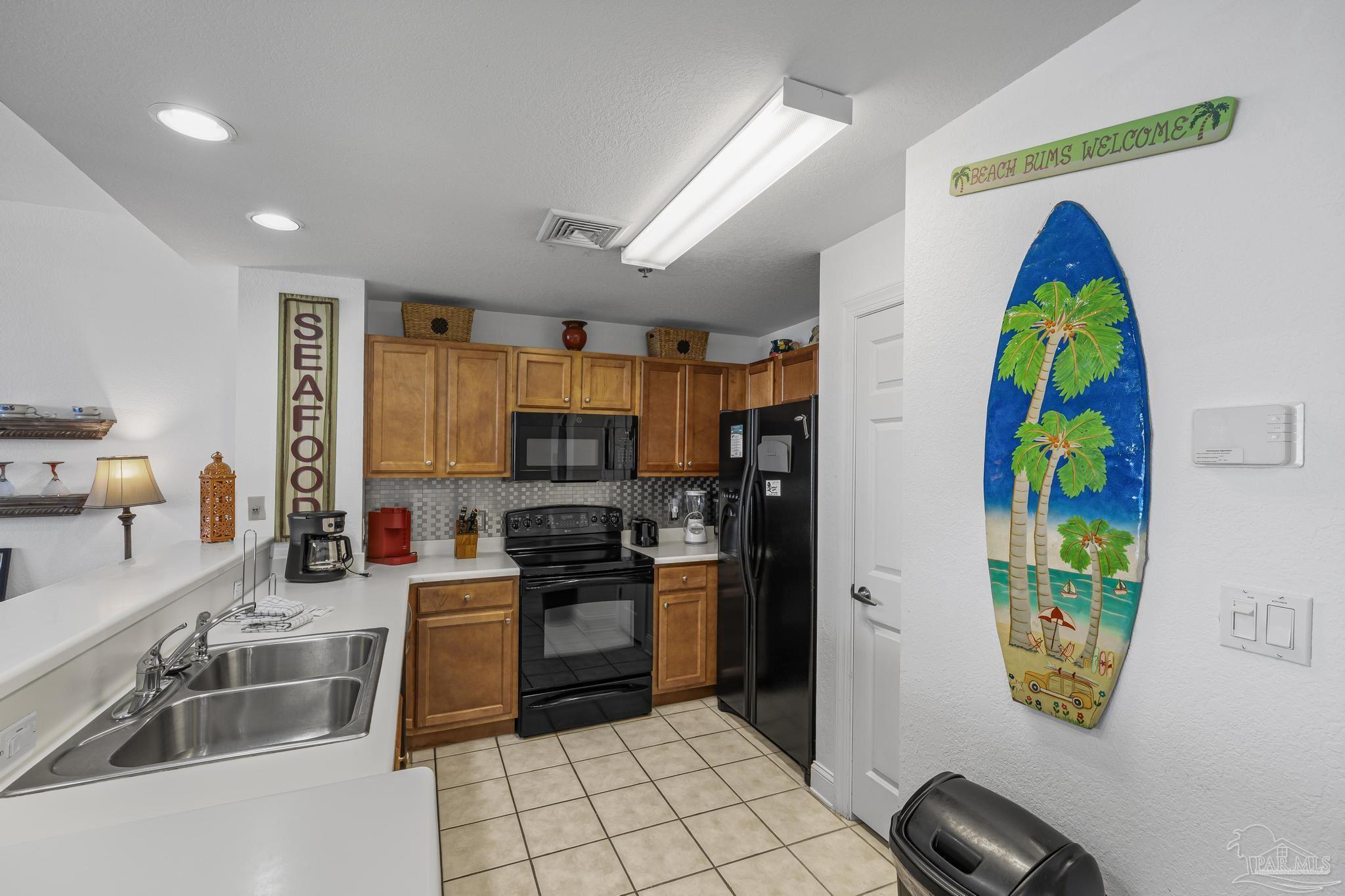 850 Fort Pickens Road, Unit 1230 Pensacola Beach, FL 32561 - Photo 16 of 67 a kitchen with stainless steel appliances granite countertop a stove a sink a refrigerator and a dining table