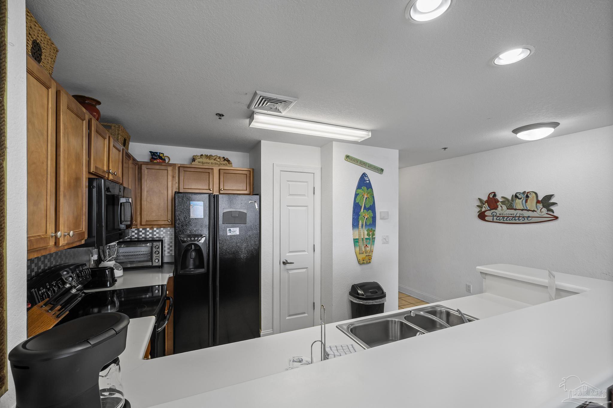 850 Fort Pickens Road, Unit 1230 Pensacola Beach, FL 32561 - Photo 18 of 67 a kitchen with a refrigerator and a sink