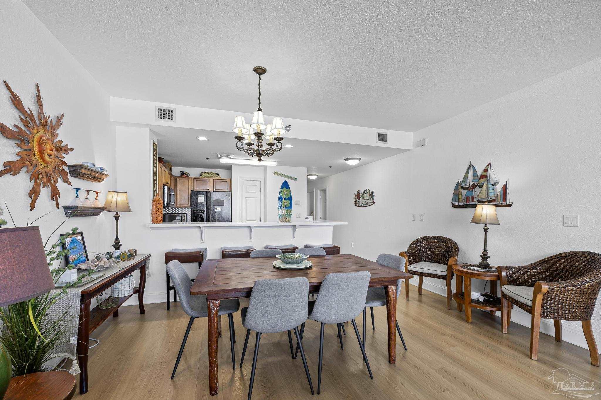 850 Fort Pickens Road, Unit 1230 Pensacola Beach, FL 32561 - Photo 21 of 67 a view of a dining room with furniture and wooden floor
