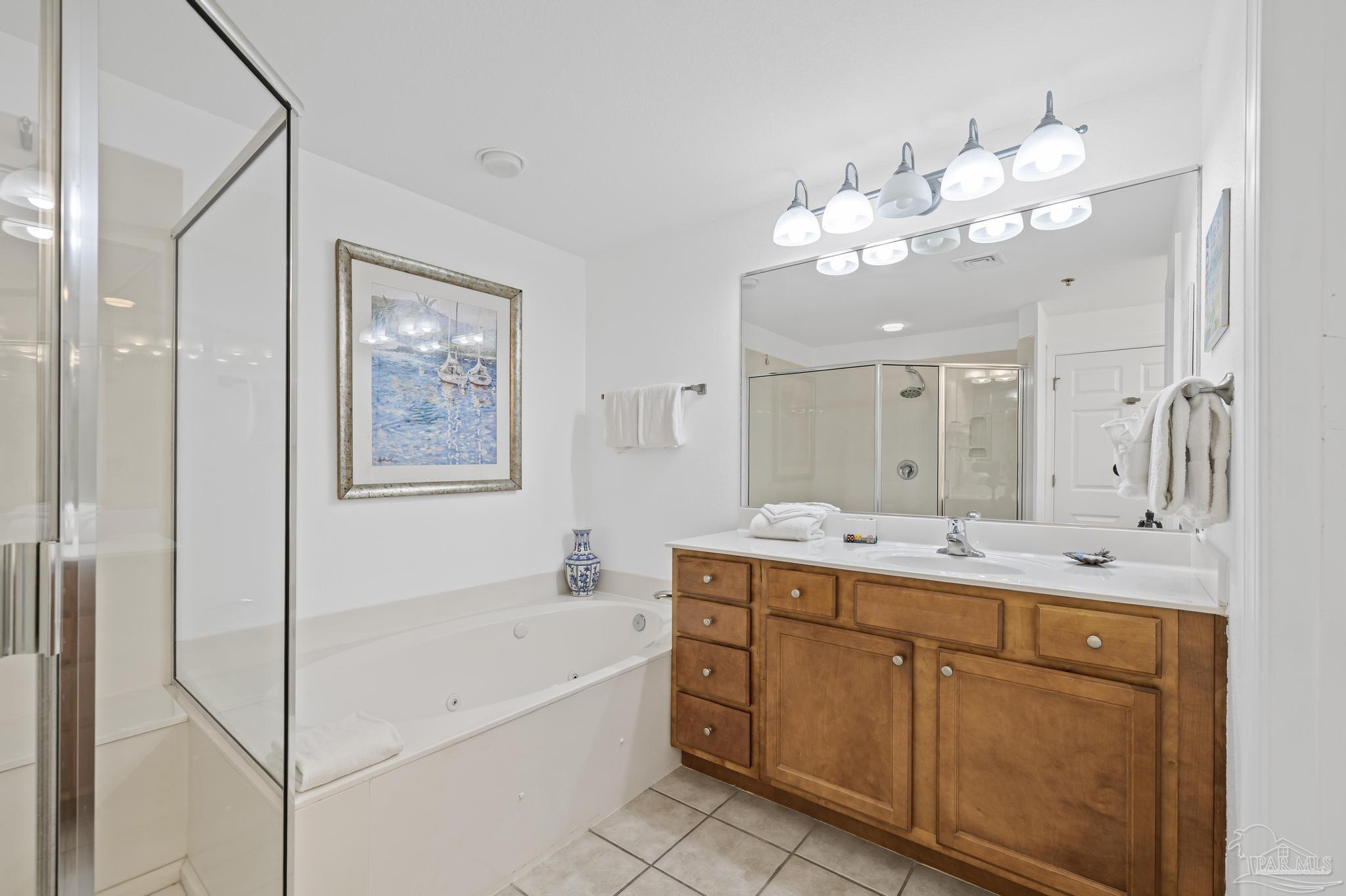 850 Fort Pickens Road, Unit 1230 Pensacola Beach, FL 32561 - Photo 30 of 67 a bathroom with a double vanity sink a large mirror and a bathtub