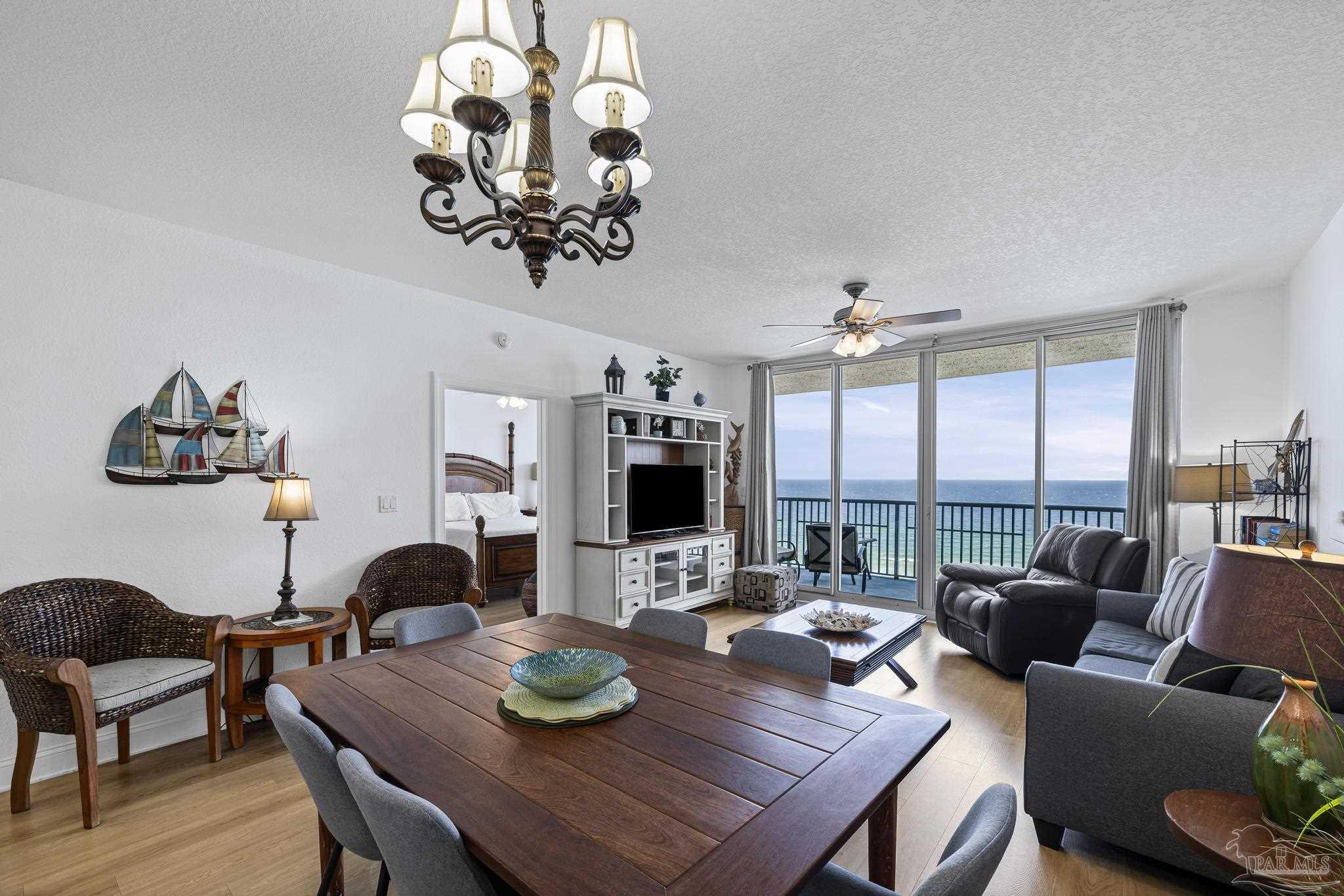 850 Fort Pickens Road, Unit 1230 Pensacola Beach, FL 32561 - Photo 4 of 67 a view of a dining room with furniture large windows and wooden floor