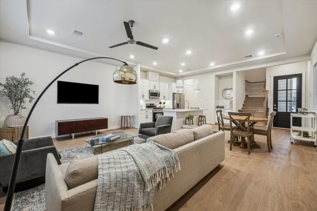 a living room with furniture a flat screen tv and kitchen view