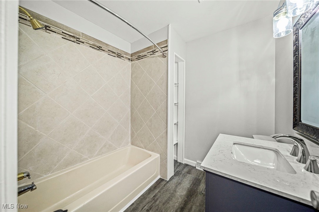 91 Paradise Road Painesville, OH 44077 - Photo 26 of 39 Bathroom featuring shower / bath combination, dark wood finished floors, and vanity