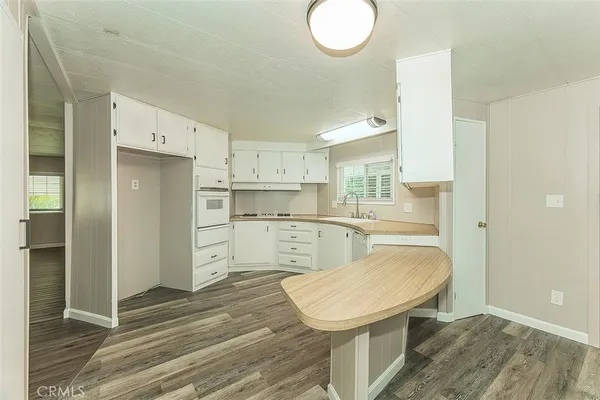 a view of a kitchen with wooden floor and a ceiling fan