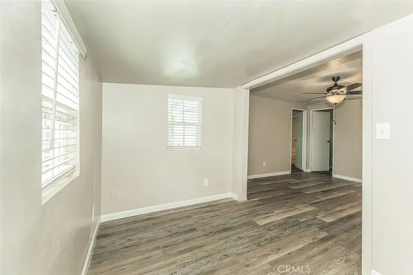 an empty room with fan and windows