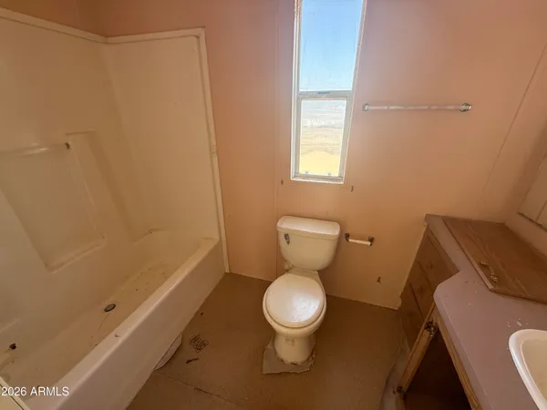 a bathroom with a sink toilet and window