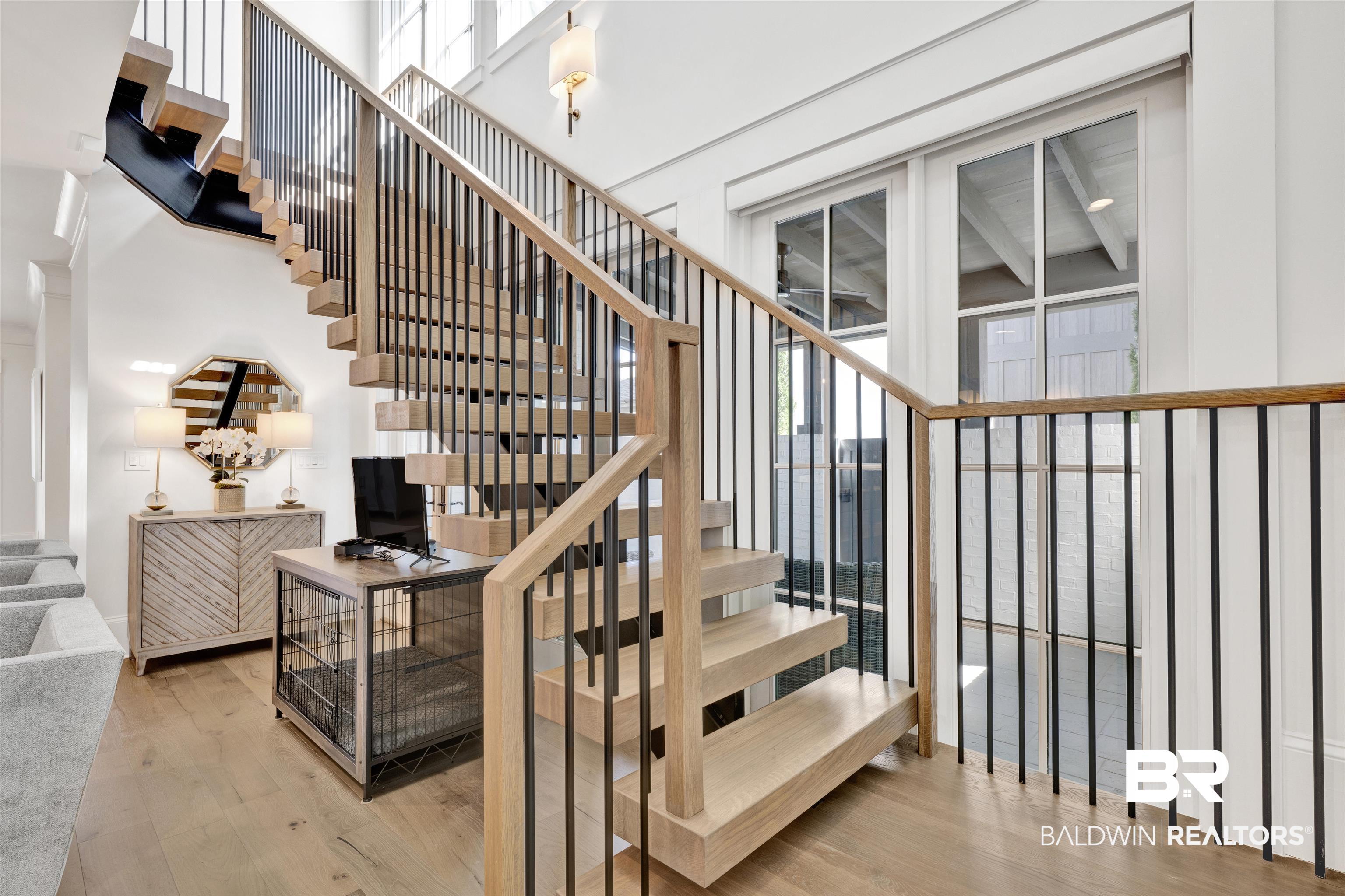 861 Inlet Circle Gulf Shores, AL 36542 - Photo 21 of 54 Stairs featuring wood finished floors and a high ceiling