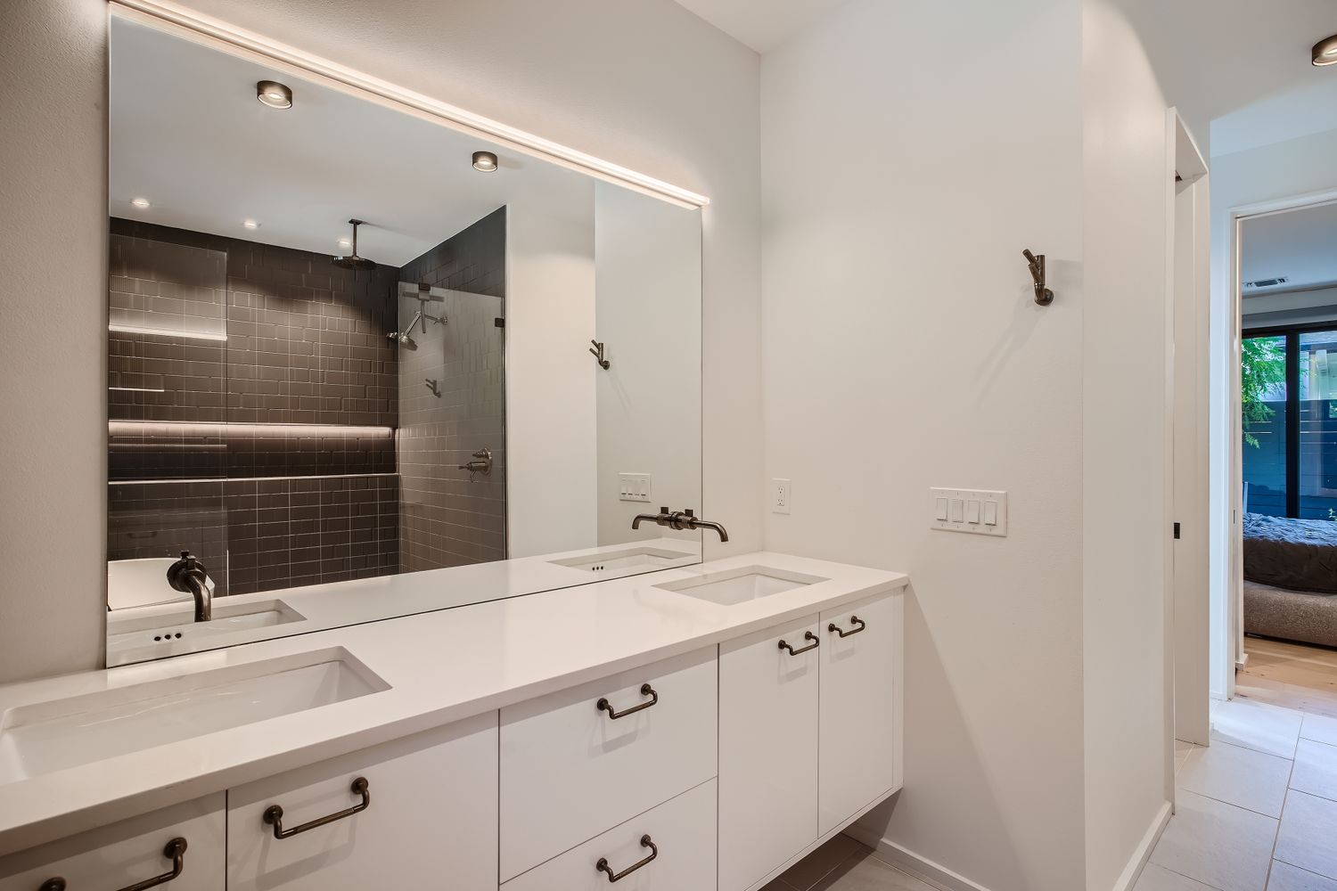 7525 Delafield Lane, Unit A Austin, TX 78752 - Photo 18 of 33 Ensuite bathroom featuring double vanity, a tile shower, recessed lighting, and light tile patterned flooring