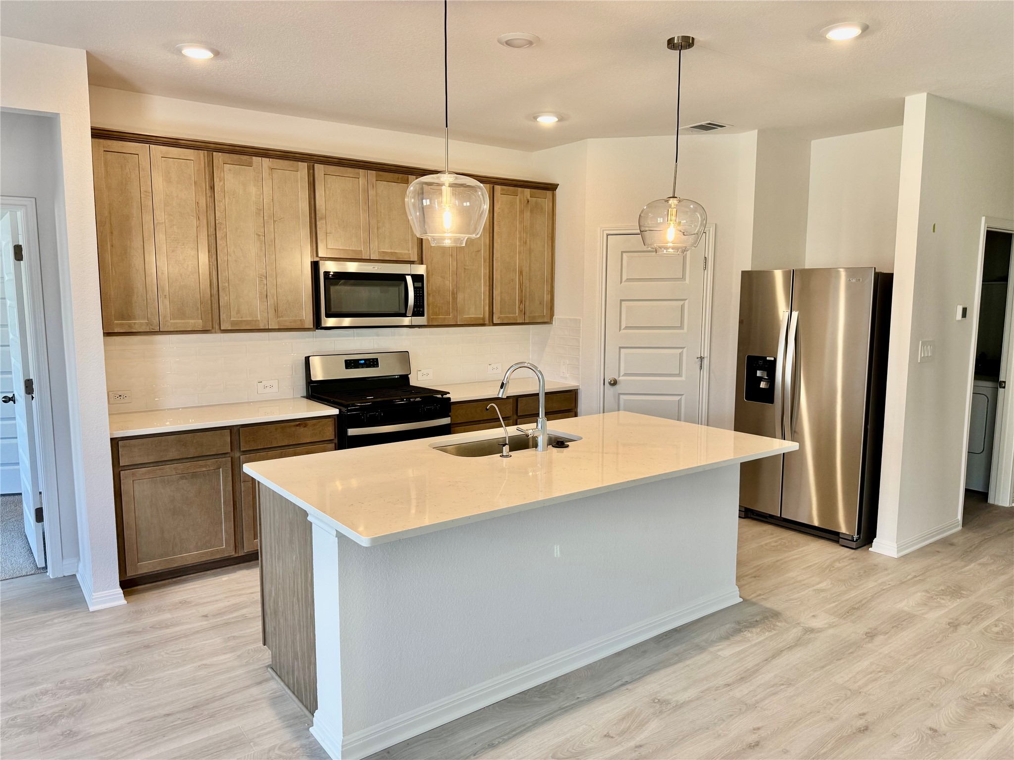 470 El Capitan Loop Dripping Springs, TX 78620 - Photo 2 of 26 a large kitchen with stainless steel appliances a large counter top and wooden floor