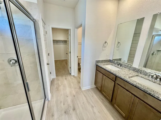 a bathroom with a granite countertop sink a mirror and a shower
