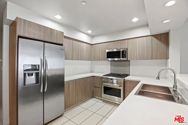 a kitchen with a refrigerator sink and stainless steel appliances