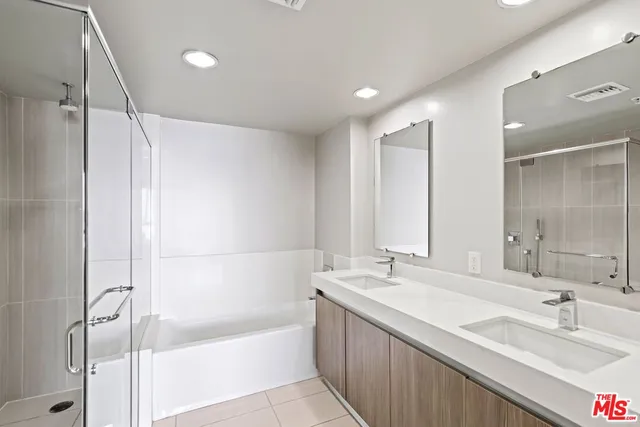 a bathroom with a bathtub shower sink and mirror