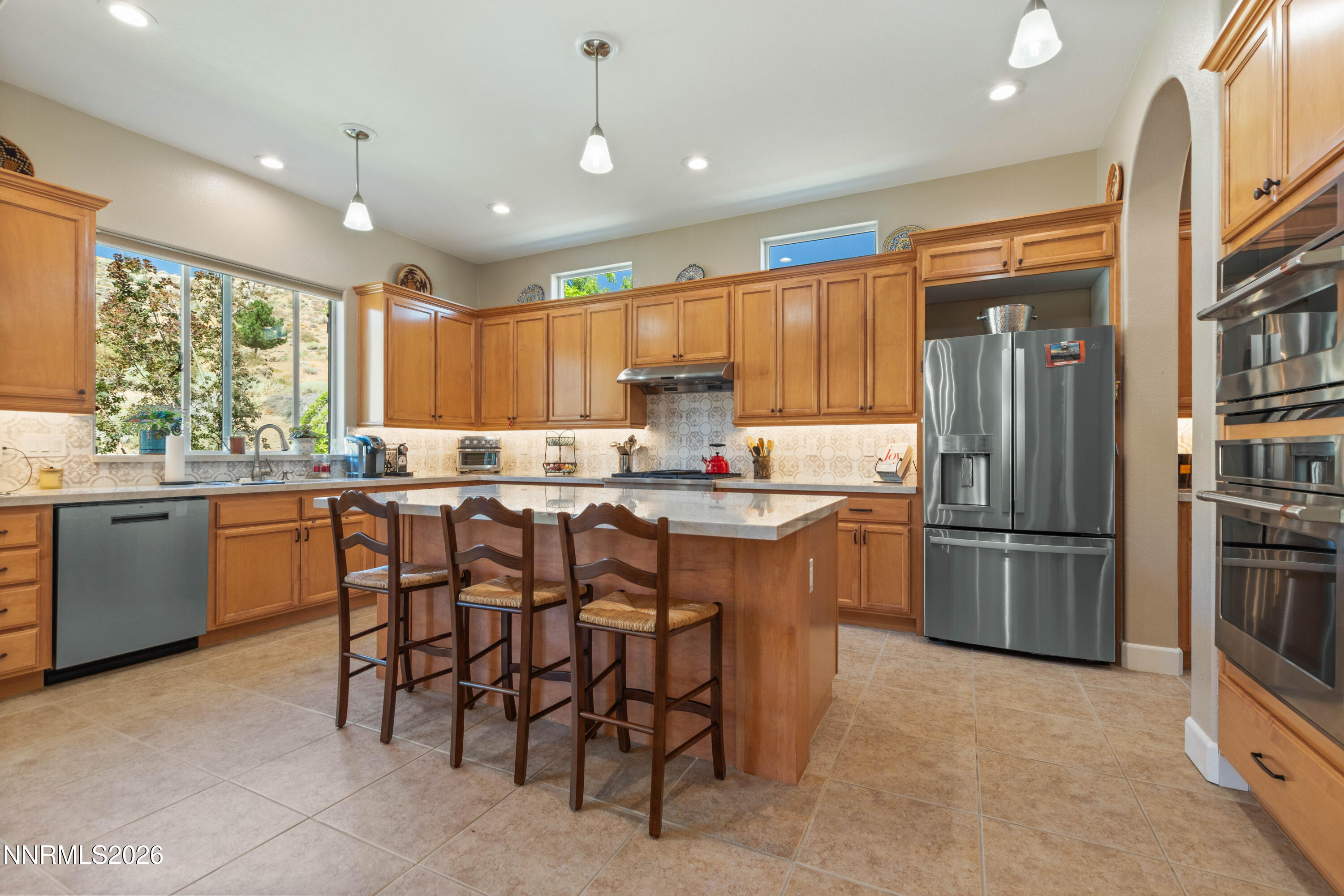 2395 Ridge Field Trail Reno, NV 89523 - Photo 10 of 44 a kitchen with a refrigerator a sink a stove a dining table and chairs