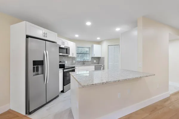 a kitchen with stainless steel appliances granite countertop a refrigerator sink and stove