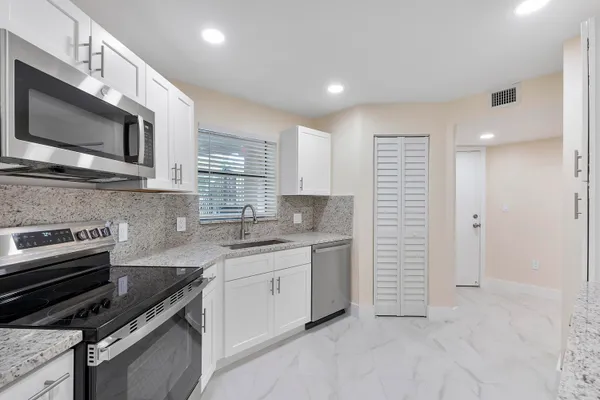 a kitchen with stainless steel appliances a sink stove and microwave