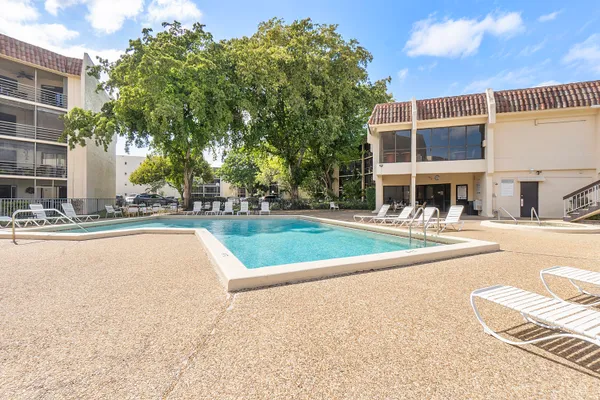 a view of a house with a swimming pool and sitting area