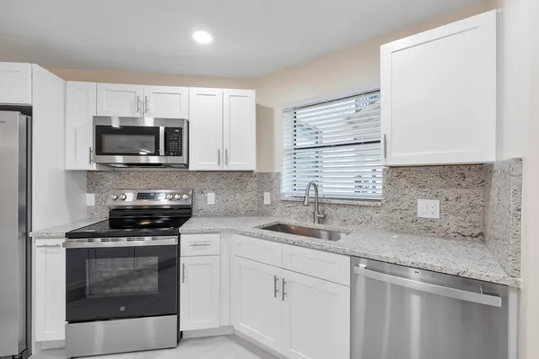 a kitchen with a sink stove and microwave