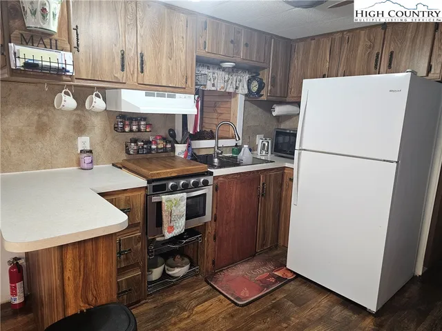 a kitchen with a refrigerator a stove a sink and cabinets